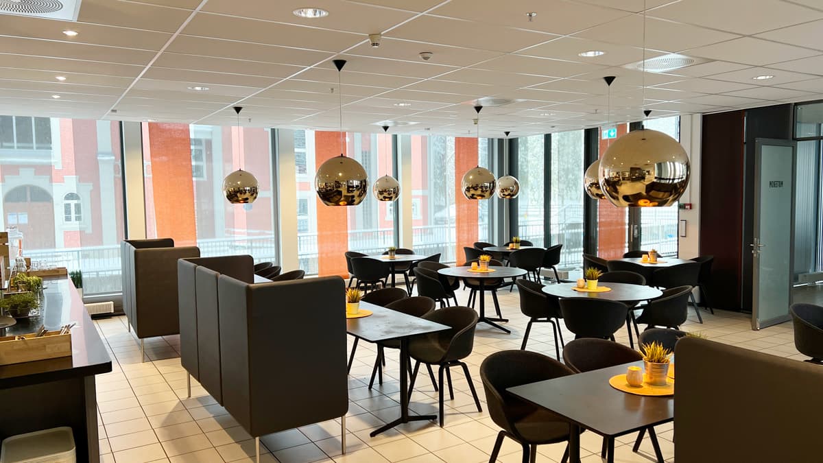 The shared canteen at Grønland 1, with seating and large windows.