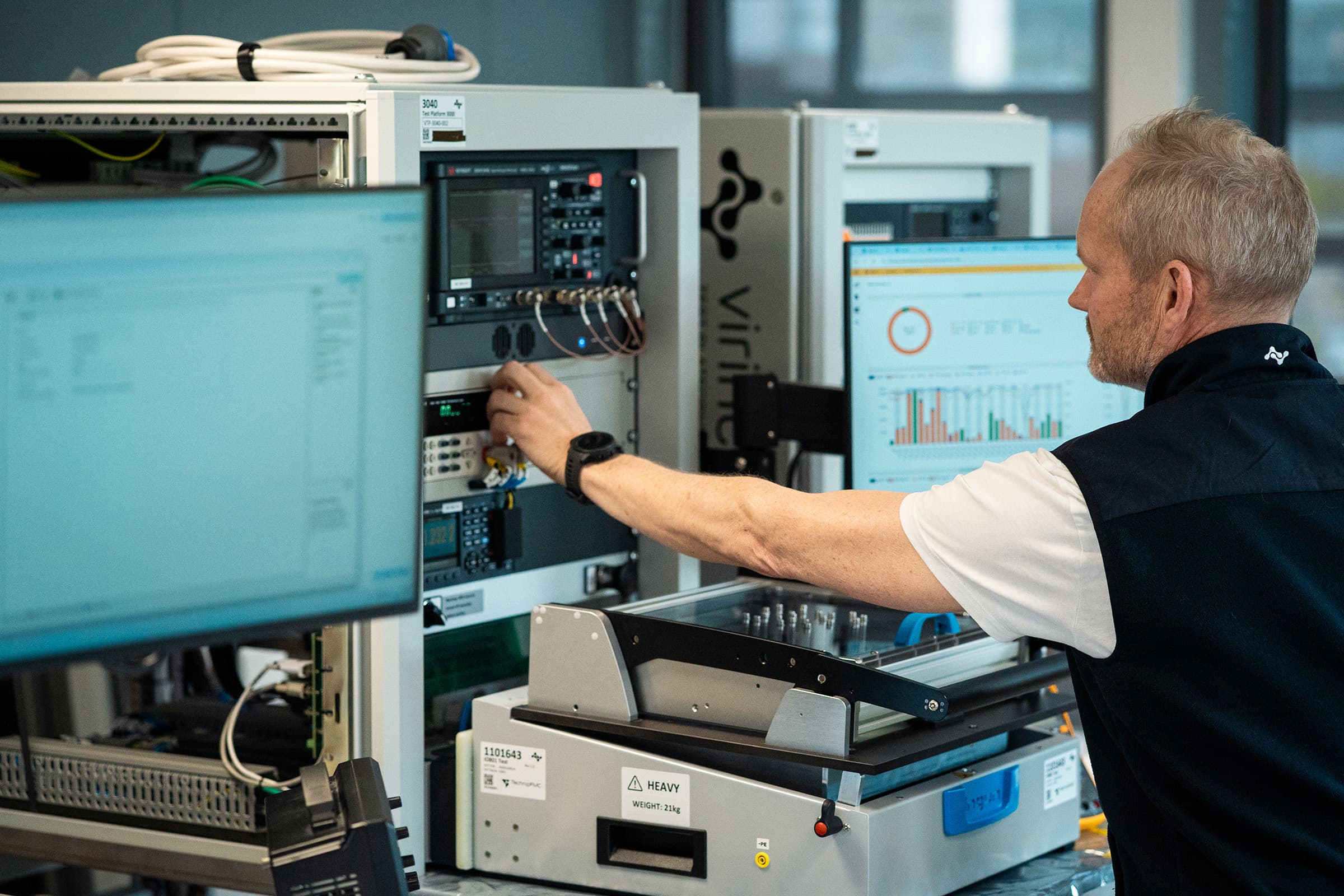 A Virinco engineer adjusting instrumentation on a Test Platform 3000 rack in a lab.
