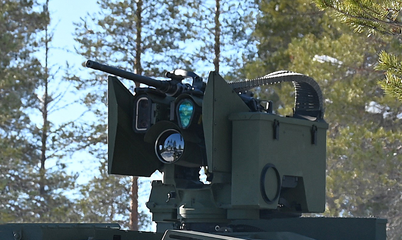 Close-up of the PROTECTOR remote weapon station showing the sensor unit and weapon assembly.